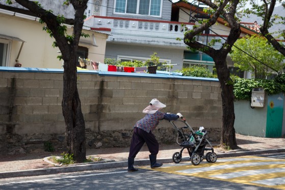 A woman pushes groceries in a stroller