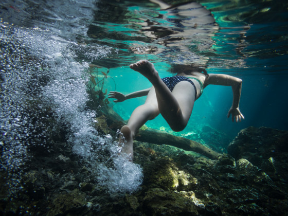 A girl swimming in Gran Cenote - Tulum, Mexico